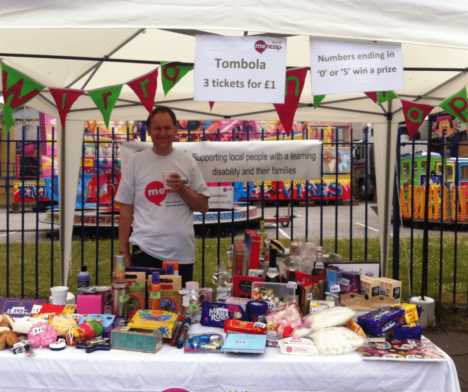 A volunteer manning the tombola stand