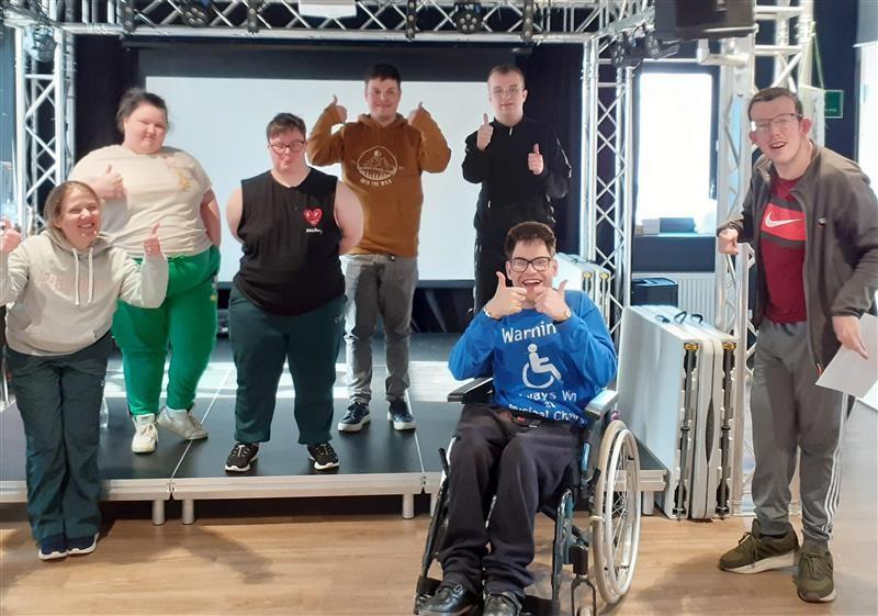 A group of people smiling with their thumbs up